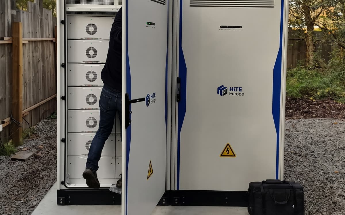 Een open batterijkast met de modules boven elkaar, naast een gesloten kast