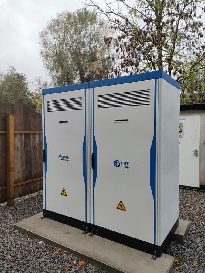 Twee geplaatste batterijkasten op een betonnen plaat, vastgeschroefd op hun sokkel